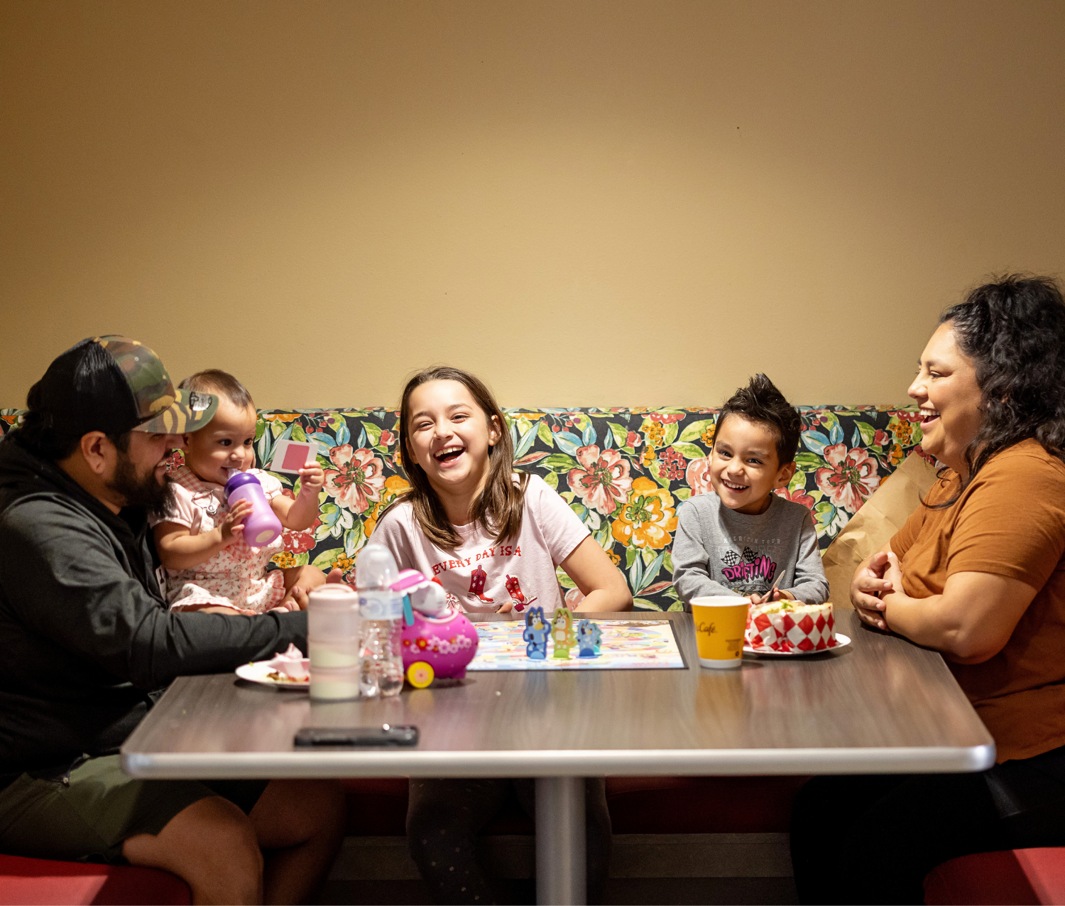 Family of five around a dinner table at a Ronald McDonald House laughing together