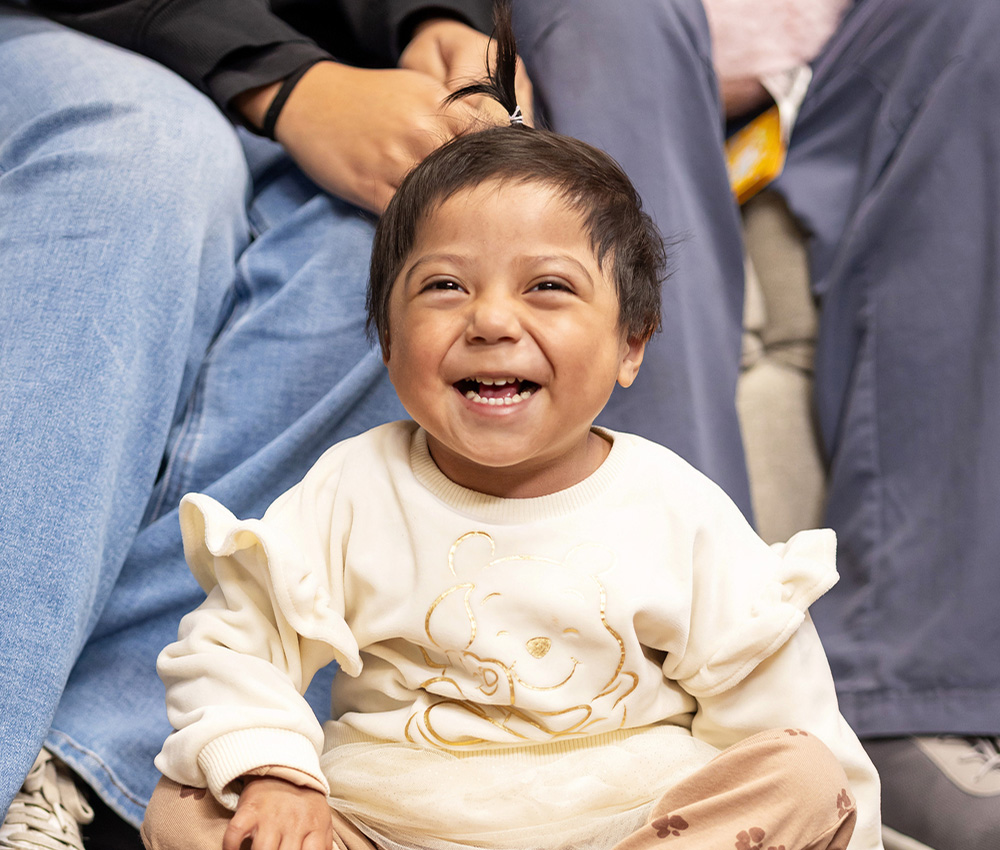 toddler sitting on floor happily