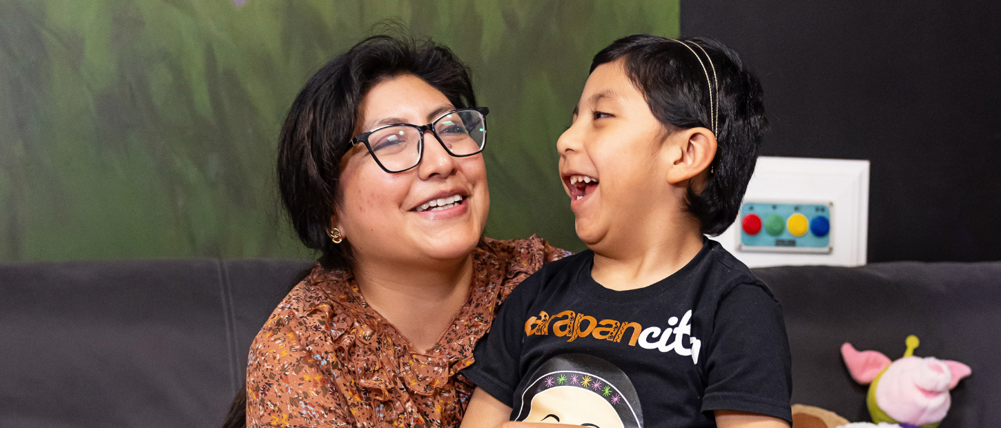 Mom and daughter laughing together in a play room