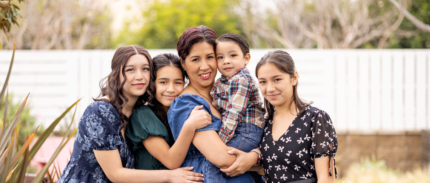Mom holds son while her 3 daughters hug them.