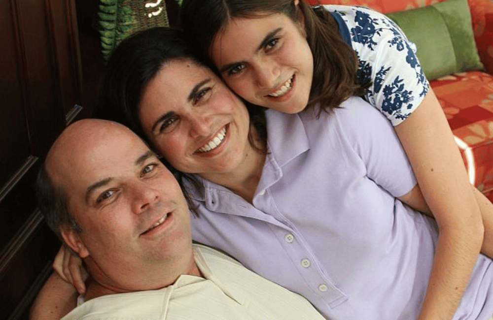 Mom and dad with daughter holding each other close