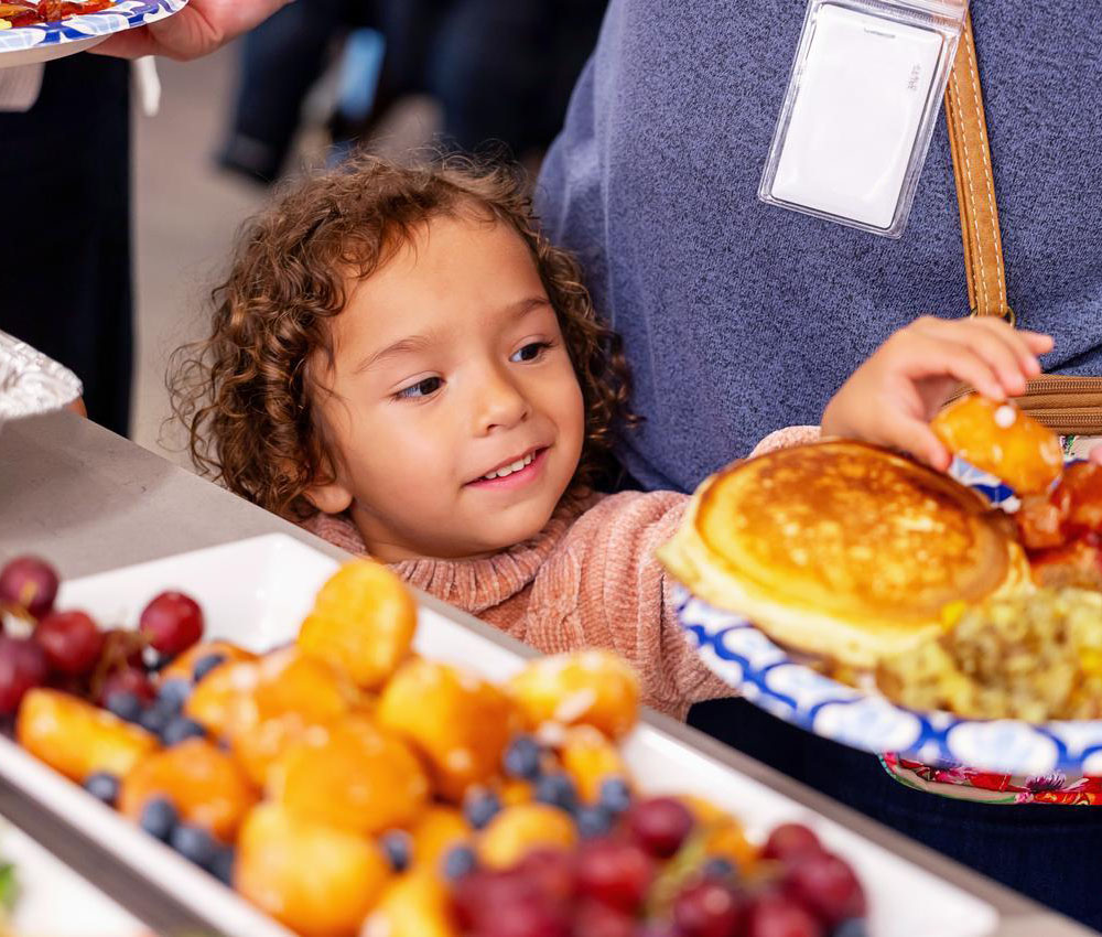 girl in dining hall looking at tray of food